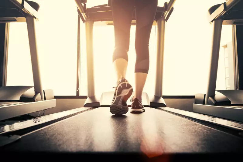 Women in gym on treadmill.