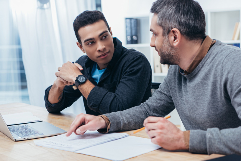 Young mentee with experienced mentor in bright and modern office.