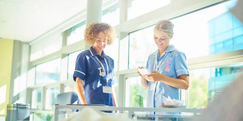 Two NHS Nurses Talking About Patients Charts