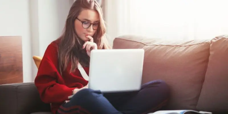 Woman Studying On A Laptop Sat On The Sofa