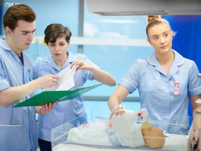 trainee midwife giving doll oxygen