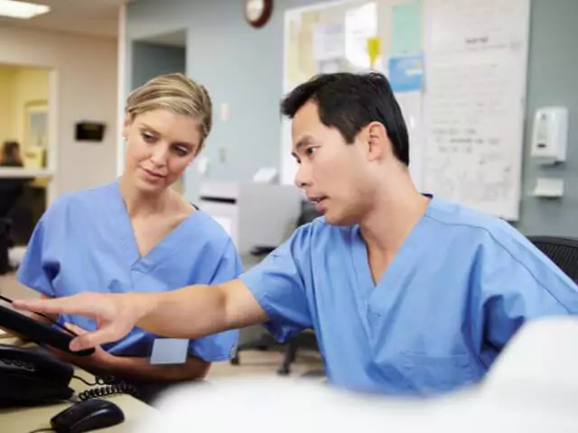 two nurses talking whilst looking at computer