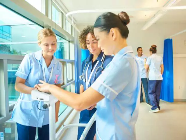 three nurses using machine in hospital