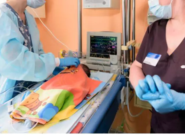 noenatal nurse putting blanket on baby