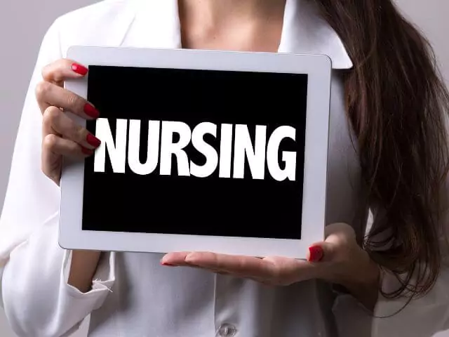 nurse holding chalkboard reading nursing