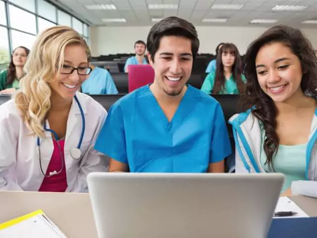 student nurses in classroom learning on laptop