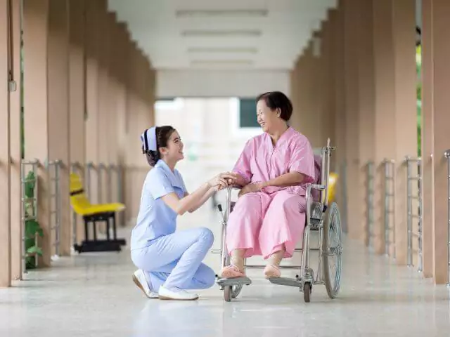 nurse talking to patient in wheelchair