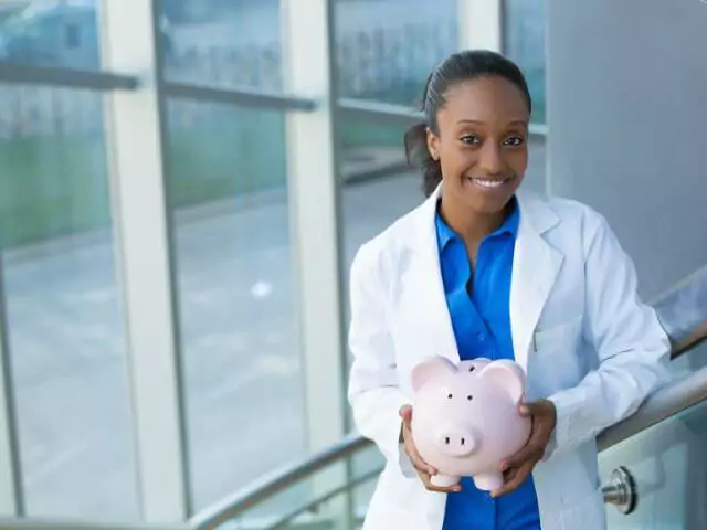 nurse holding pink piggy bank