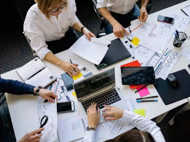 group of people working around desk