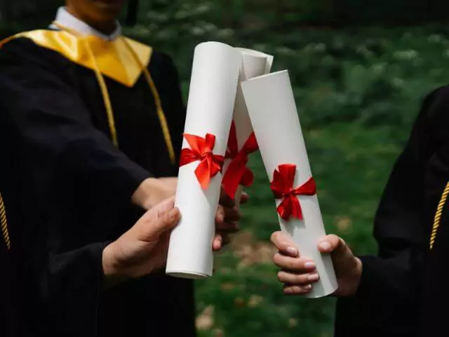 university students holding diploma certificates