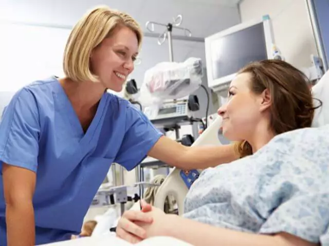 nurse talking to patient laying in bed