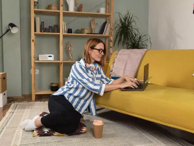 woman studying on laptop sitting on the floor