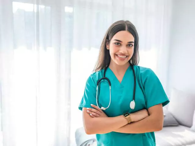 nurse in green uniform looking at camera