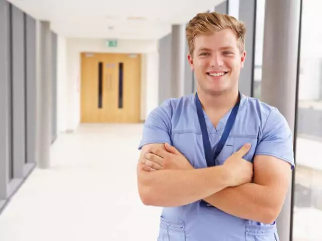 male nurse standing in hospital corridor