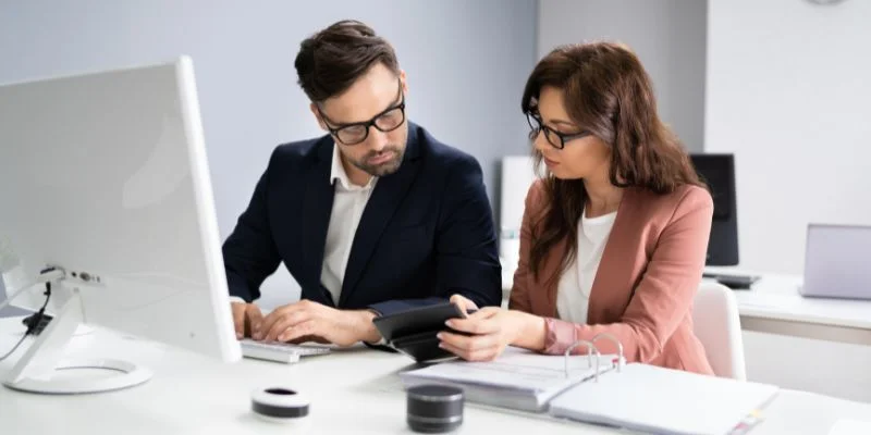 man and woman using calculator for accounts