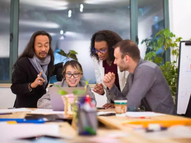 group stood around working on a laptop