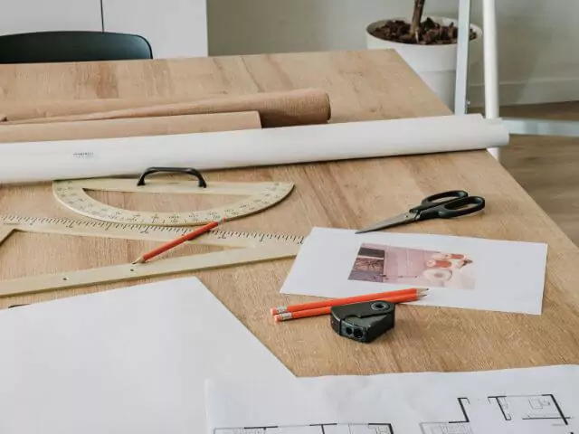How To Become An Interior Designer (designers-desk-containing-plans-and-samples.webp)