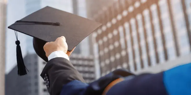 student holding university cap