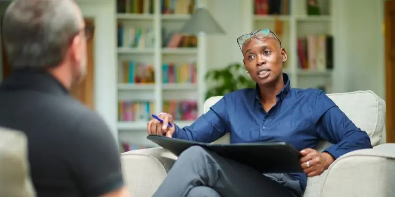 counsellor talking to patient sat on sofa