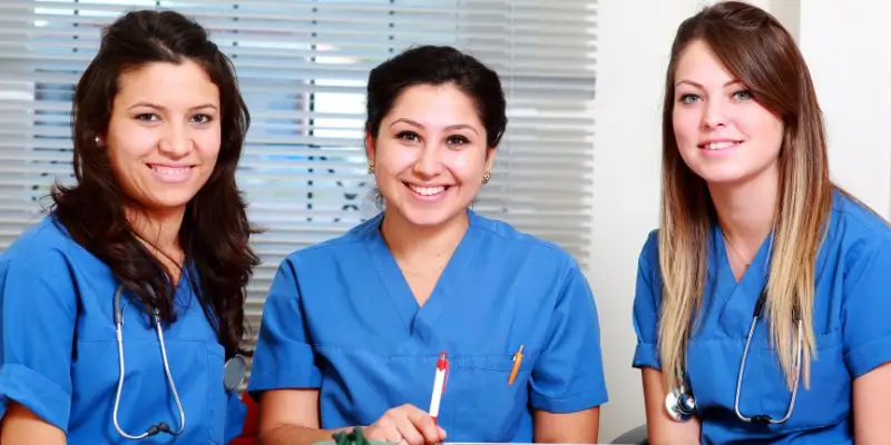 three nurses looking at the camera smiling
