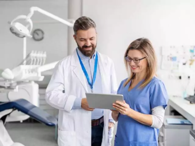 dental nurse talking to dentist about patient