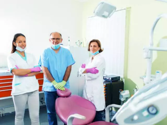 dentist and two dental nurses standing in surgery