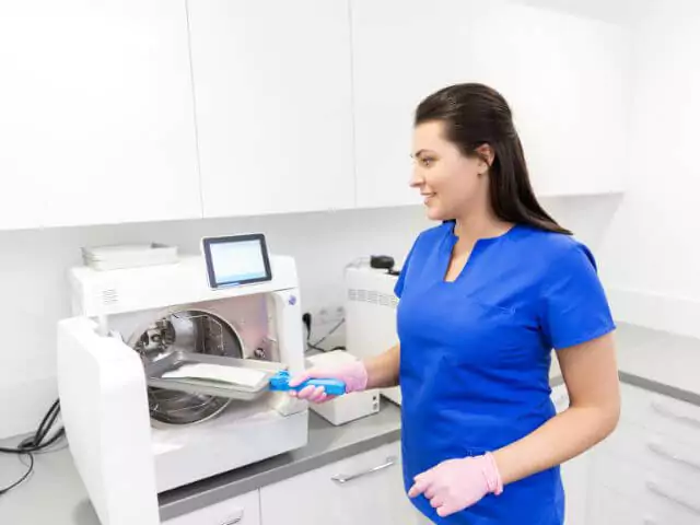 dental nurse cleaning dental equipment