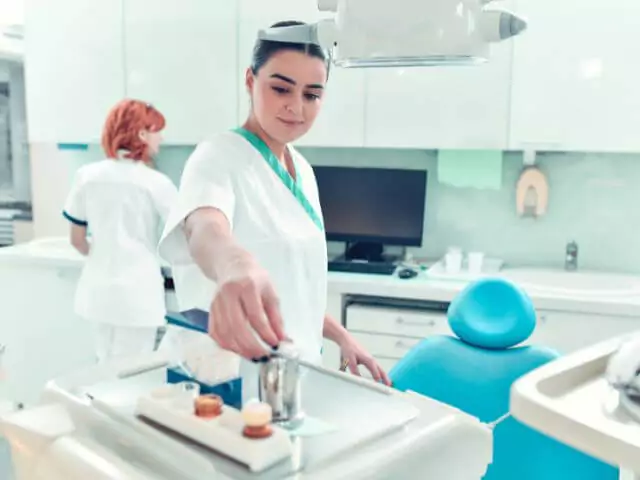 dental nurse sorting dental equipment in surgery