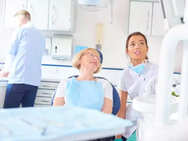 dental nurse talking to patient in surgery