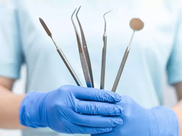 dental nurse holding dental equipment