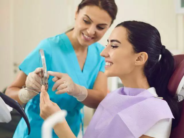 dental nurse showing patient teeth in mirror