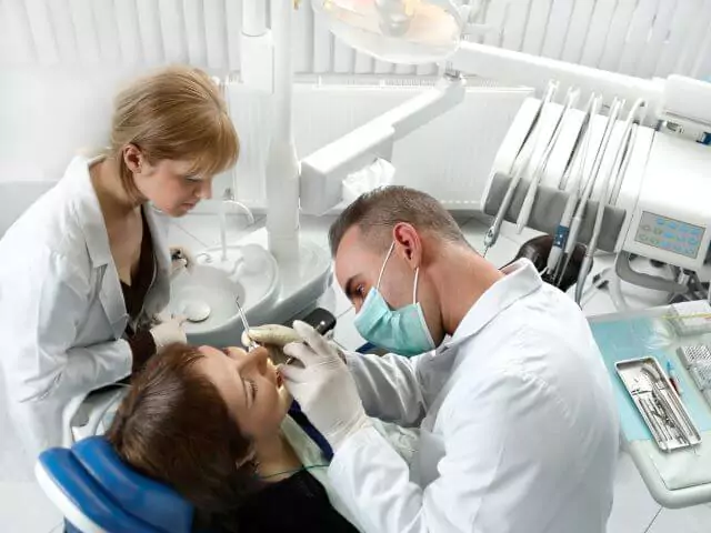 dental nurse helping dentist with patients teeth