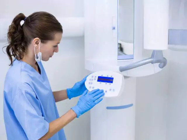 dental nurse setting up radiography machine