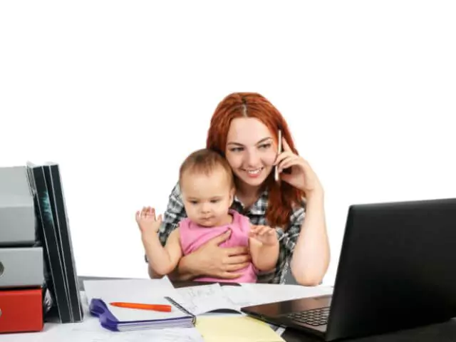 Woman On Phone With Baby Sitting At Computer