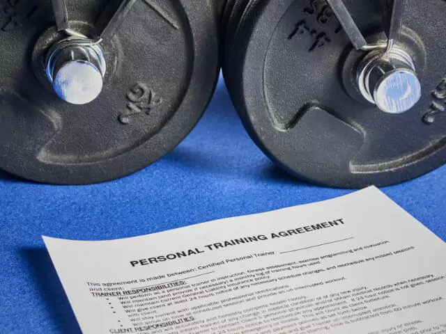 personal training contract next to dumbbells