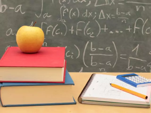 books and apple on teachers desk
