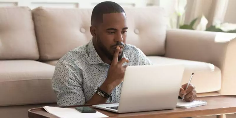 man sitting with laptop doing online course