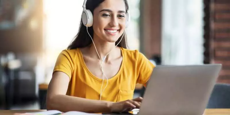 woman studying on laptop with headphones on