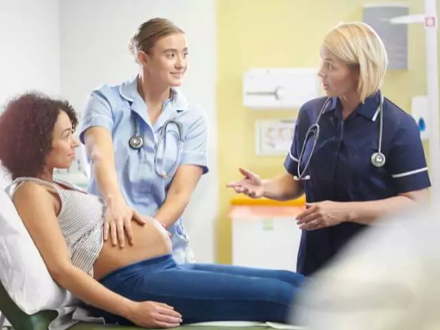 midwife talking to trainee nurse and pregnant woman