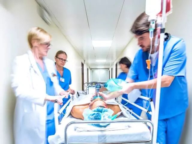 Doctors And Nurses Taking Patient On Trolley