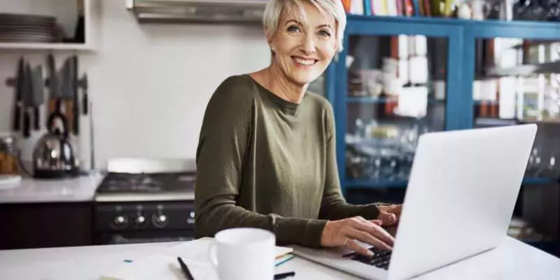 smiling older woman working on laptop