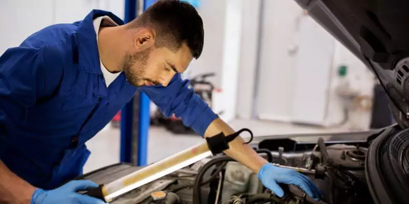 man looking inside car engine