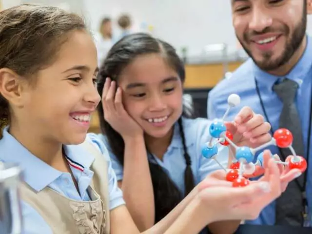 pupils learning about molecules with science teacher