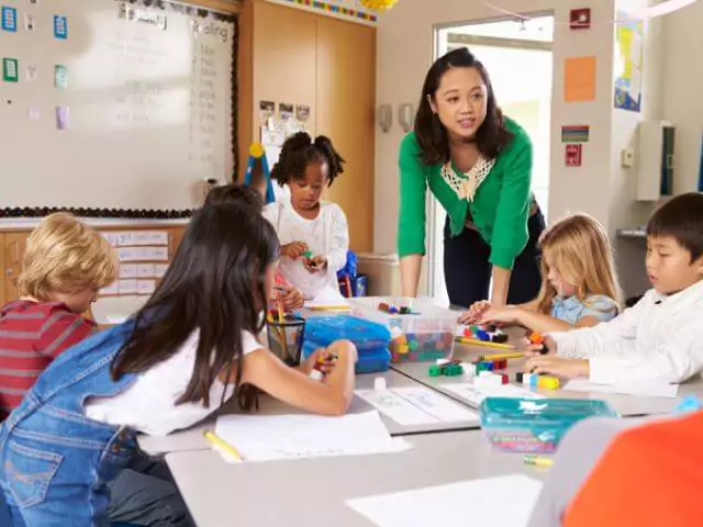 teaching assistant talking to group of pupils