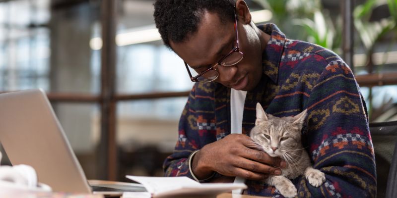 man working cuddling cat